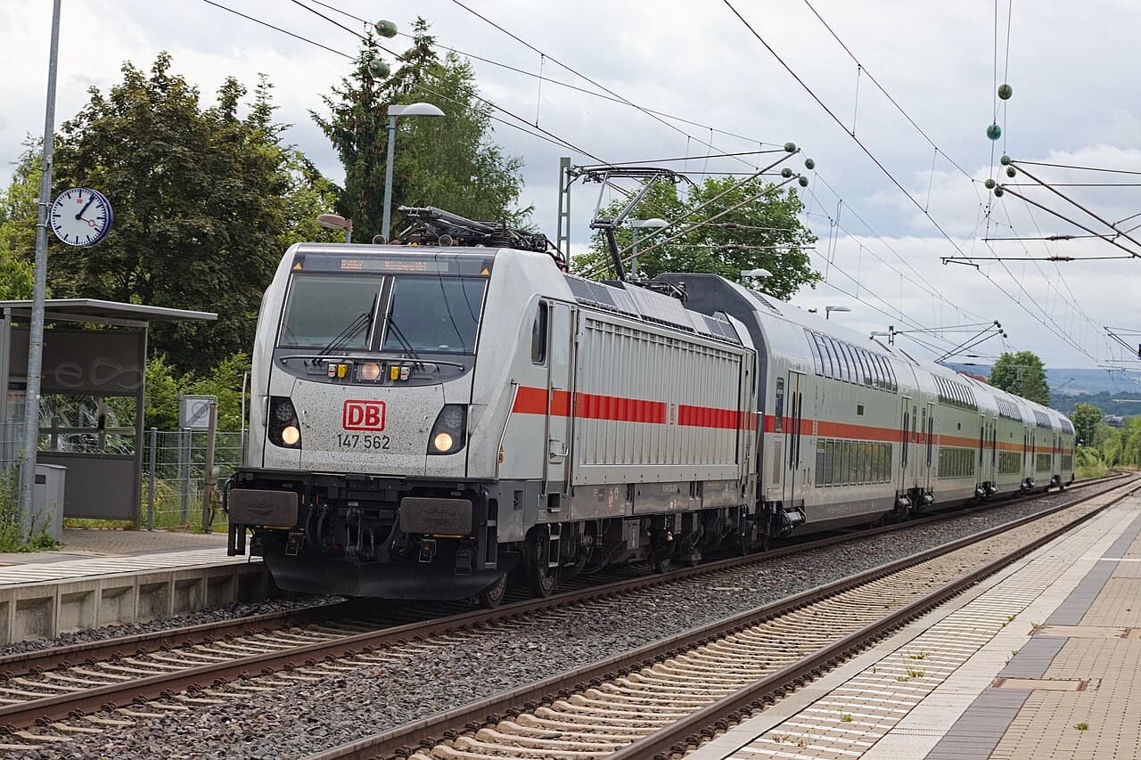DB Intercity 2: a white class 147 locomotive pulling white double-deck coaches with a red stripe through a station