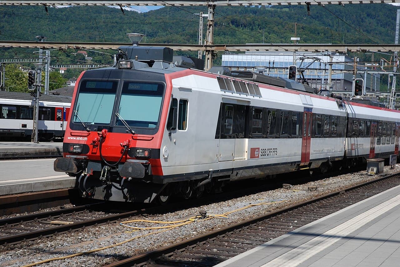 Refurbished Domino train in white livery with red front and red doors at a station platform