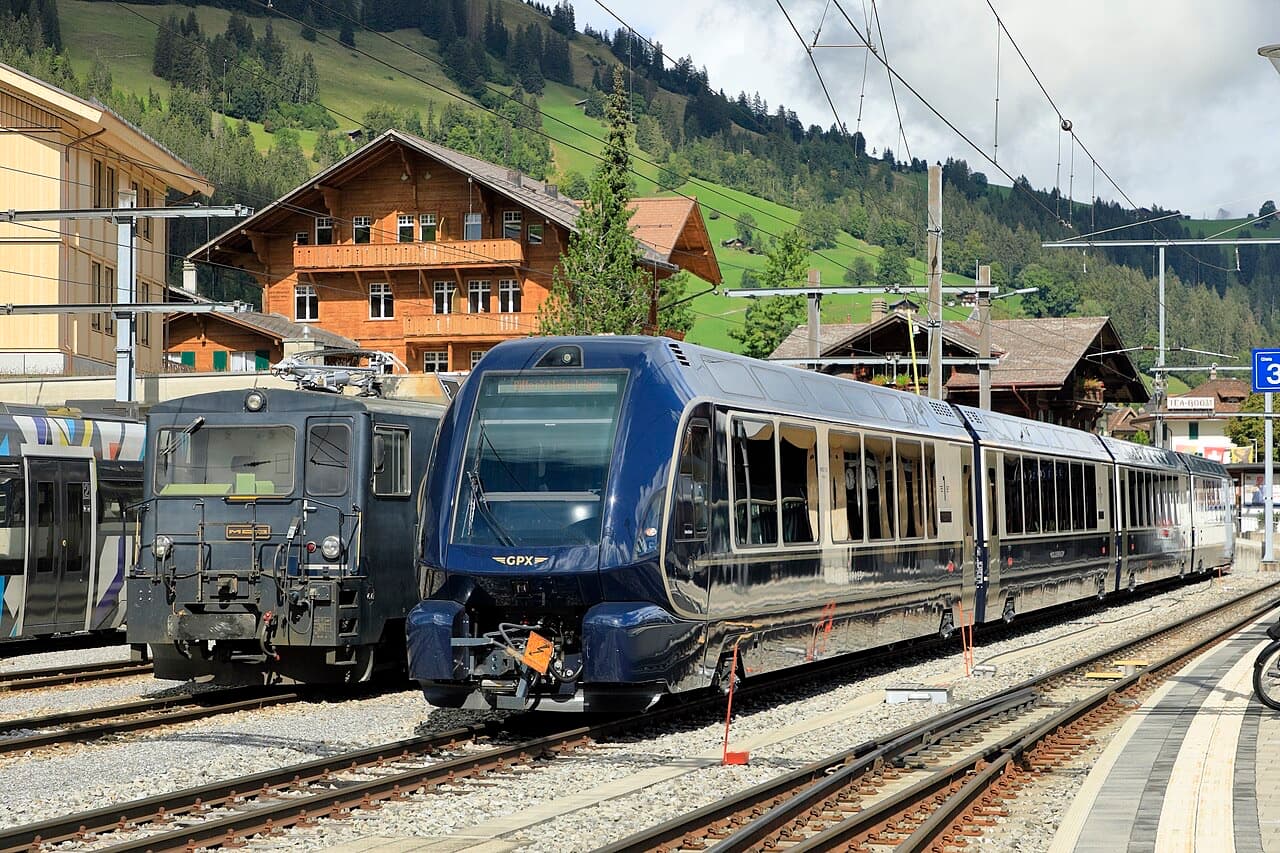 Dark-blue GoldenPass Express with panoramic cab car and large side windows at Zweisimmen