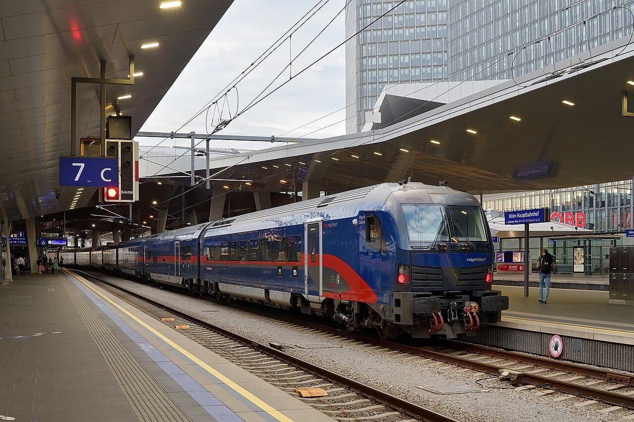 New-generation ÖBB Nightjet (Viaggio Next Level) in dark-blue livery with red swoosh, control car leading, at Wien Hauptbahnhof