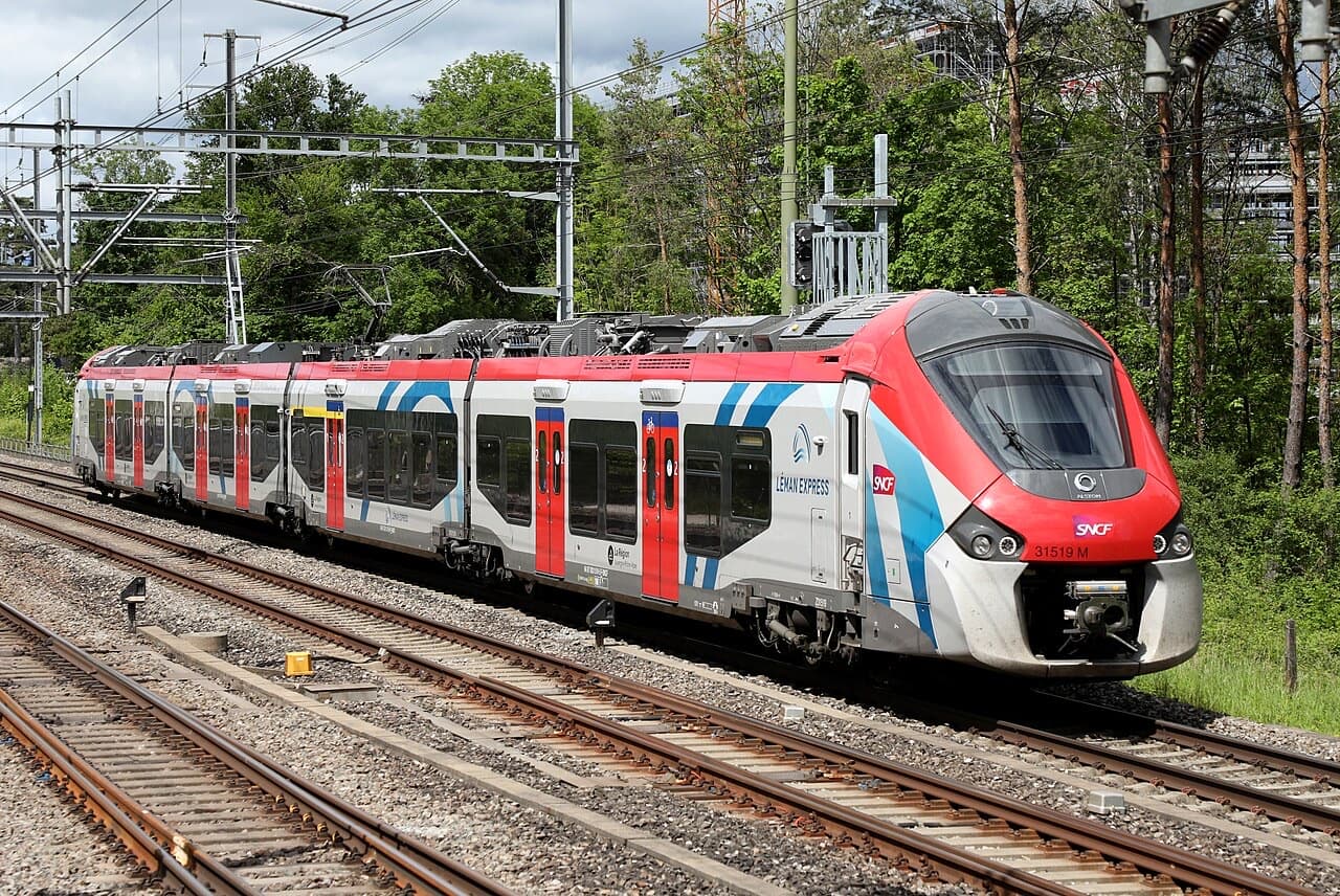 SNCF Régiolis Z 31500 in Léman Express livery with red nose and blue-striped white sides near Chambésy