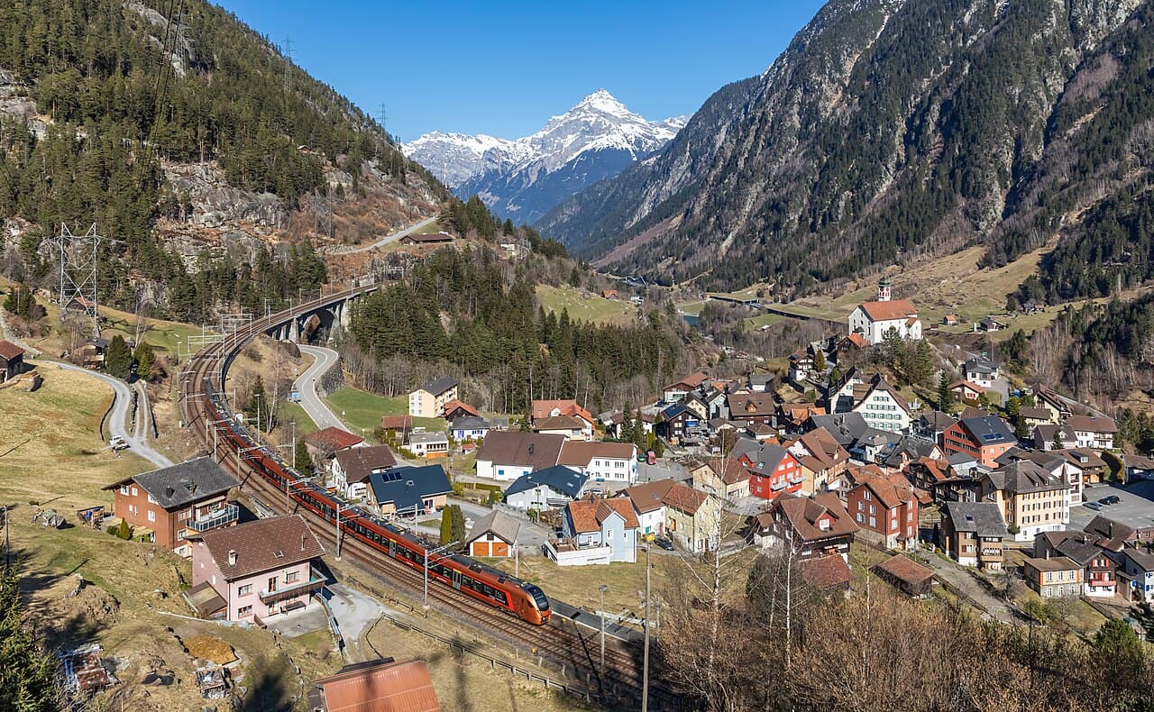 Copper-coloured SOB Traverso on the Gotthard line passing the village of Wassen